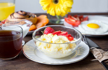 Breakfast table served with corn porridge, fried egg and juice