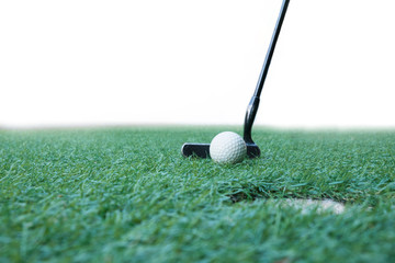 Golf ball on green field with putter and golf hole