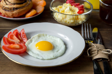 Breakfast table served with corn porridge, fried egg and juice