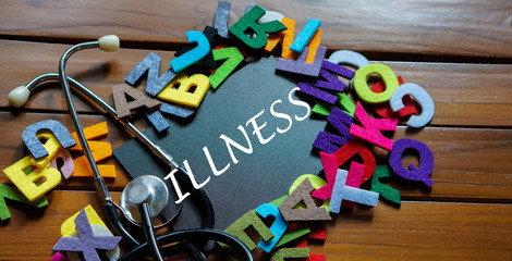 Black board written with " ILLNESS " and stethoscope on wooden back ground.Image with selective focus.Medical and health care concept.