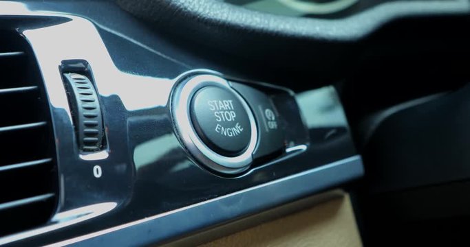 Video footage of woman finger pressing the engine start button on the car dashboard, shot in 4k resolution