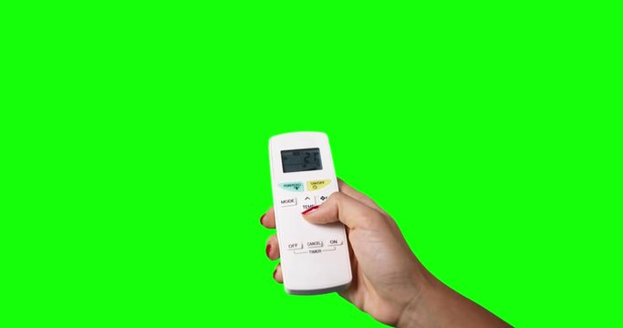 Woman hand using a remote control to change the temperature of air conditioner, shot with green screen background. Professional shot in 4K resolution