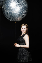 Naklejka premium The woman is standing with silver balloon