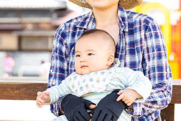 公園で座るお母さんと赤ちゃん