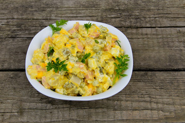 Russian traditional salad olivier on wooden table