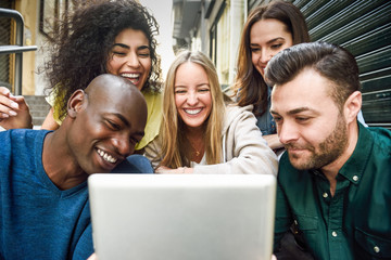 Multi-ethnic group of young people looking at a tablet computer
