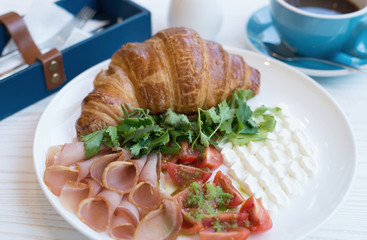 Croissant and meat on the rustic background. Concept and idea of breakfast