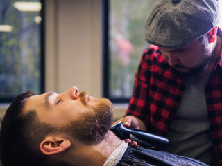 Adult male barber and customer in shop