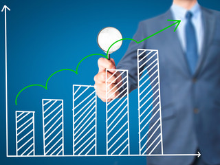 Sales Growth Graph - Business man holding magnifying glass on screen interface