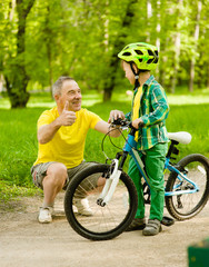 Fototapeta premium Father and son having fun riding a bike