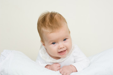 Happy newborn baby girl lying on her stomach