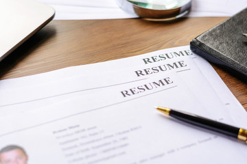 Resume, pen, magnifier, laptop on your desktop. job search 