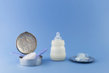Baby boy luxurious items collection isolated on pale blue background. Silver can with hairbrush and...