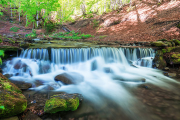 Waterfall on mountain in summer time