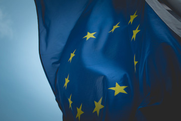 European union flag, blue sky on the background. Blue European union flag with yellow stars in a...