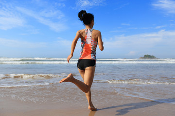 Fototapeta premium young fitness woman wear swimsuit running to the sea