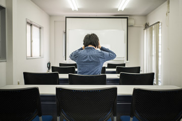 教室で悩む男性