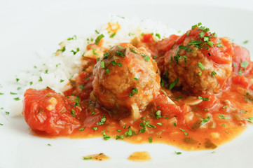 meatballs in tomato sauce and rice sprinkled with chopped parsley