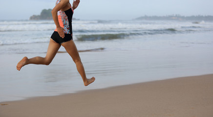  young fitness woman wear swimsuit running on beach