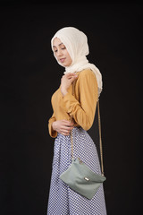 Muslim in a modern oriental clothes and handbag isolated on a black background