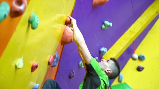Climber Man On Artificial Climbing Wall In Bouldering Gym Without Insurance. Slow Motion Effect