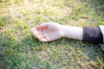 草むらに寝転ぶ女性の手