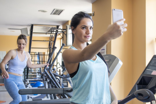 Girl taking selfie by phone on gym