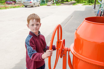 The child plays a builder with a concrete mixer