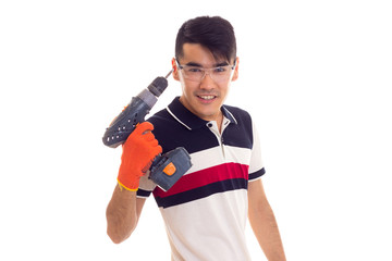 Young man with gloves and glasses holding electric screwdriver