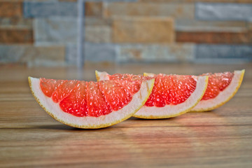 Closeup of grapefruit wedges on a wooden table