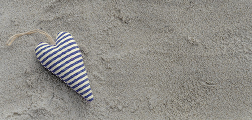 Fototapeta na wymiar Herz, blau weiß gestreift Sandstrand Hintergrund