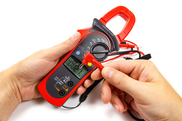 Digital clamp multimeter with probes in man's hand on a white background