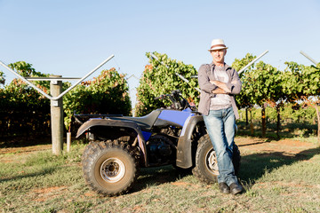 Obraz premium Man standing next to truck in vineyard