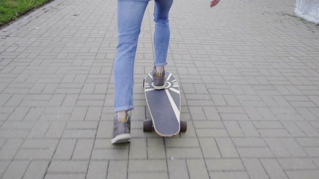 Slow motion of legs picking up and riding the board