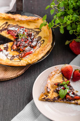 Pancake in oven, dutch baby pancake with strawberries