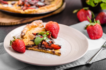 Pancake in oven, dutch baby pancake with strawberries