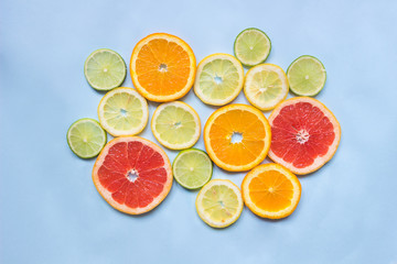 Grapefruit, orange, lemon and lime on the blue background, top view