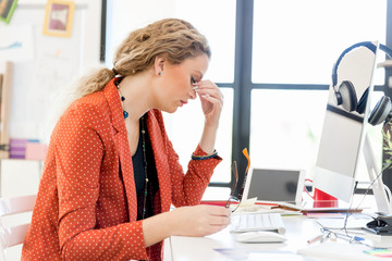 Obraz premium Young woman in office tired