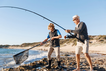 Senior man fishing with his grandson