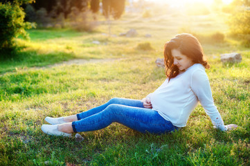 Beautiful pregnant woman relaxing in the park