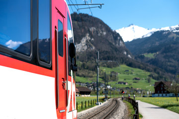 Obraz premium Red train and hills. Swiss Alps 