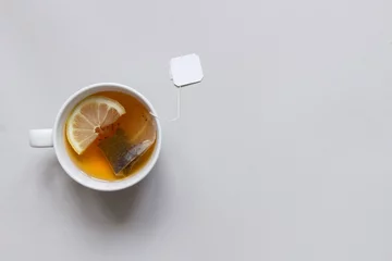 Papier Peint photo Lavable Theé L& 39 heure du thé. Tasse de thé noir chaud sur fond bleu, vue de dessus