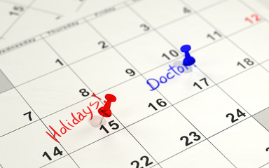 Red and blue pins marking the important days on a calendar