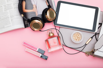gold headphones; pеrfume; powder on pink background. flat lay