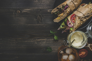 Fresh delicious submarine sandwiches on the wooden table. Top view