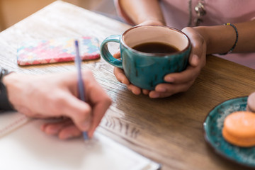Girl drinking hot beverage near boyfriend