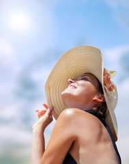 Woman in big straw hat in sun shine