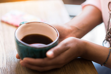 Girl holding cup of hot drink