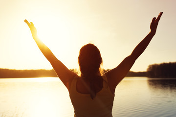 Fototapeta premium Happy woman enjoying sunset time near water