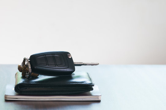 The Car Key And Wallet And Passport Isolated On The Wooded Table